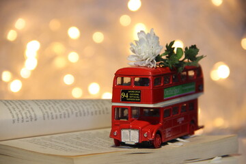 a little red english autobus with white flower