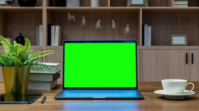 Laptop with green screen on the table. Work from home.