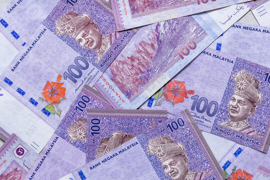 scattered Malaysian money banknotes of one hundred ringgit, Business economic background
