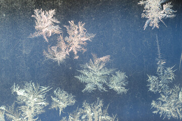 It is a pattern of frost on the glass of a window. White textured frosty crystal snowflake. Natural frost floral pattern with abstract lines, stems, and snowflakes.