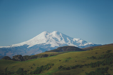 picturesque beautiful view of Elbrus, green fields and beautiful natural nature of the Caucasian mountains, the concept of travel in Russia.