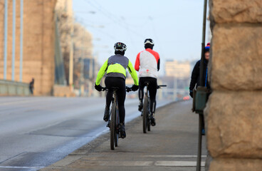 Mężczyźni jadą rowerami po moście Grunwaldzkim we Wrocławiu. - obrazy, fototapety, plakaty