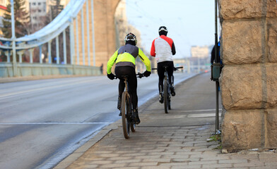 Mężczyźni jadą rowerami po moście Grunwaldzkim we Wrocławiu.