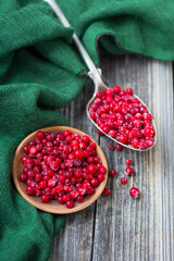 This photo shows nord style background with wooden desk , green fabric and lingonberries.  top view. Vegetarian organic food