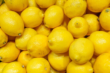 Lot of bright yellow lemons in supermarket.
