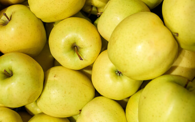 Pile of yellow apples in supermarket.