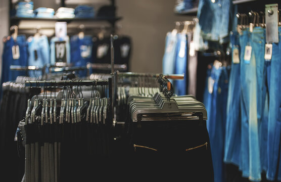 Racks with jeans and pants in clothing store.