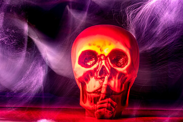 Rot angeleuchteter Totenkopf im dunklen Hintergrund mit Lichtspuren
