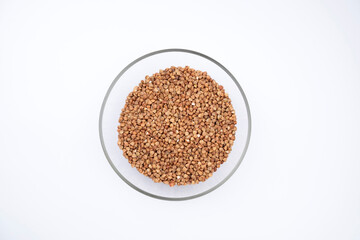 Buckwheat in glass bowl isolated on white background