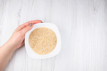 woman's hand holding a plate of rice