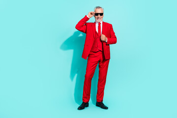 Photo of pretty retired man wear red three piece suit arm dark eyewear smiling isolated turquoise color background