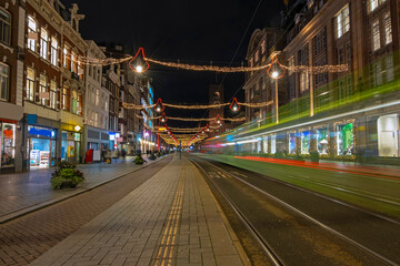 Tram driving on Damrak in christmas time in Amsterdam Netherlands