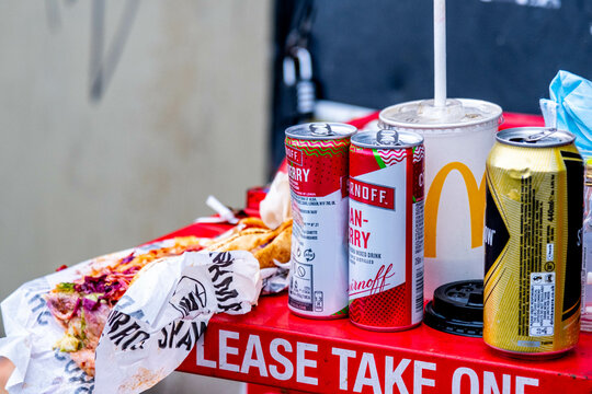 Pile Of Used Empty Cans Bottles And Food Left On Newspaper Stand Waterloo Station London