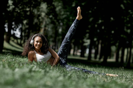 Beautiful african american latina girl doing physical exercises in the summer in the park. The concept of a healthy lifestyle.