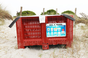 Tide tray on a beach on the sand in France.Plastic tray to put waste on the beach (France - 21/01/2022)