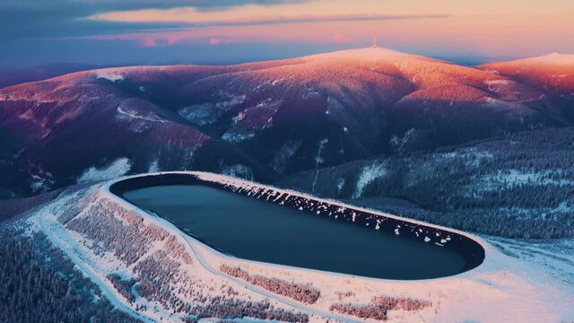 Pumped storage hydro plant "Dlouhe strane" in Jeseniky mountains during sunset. Aerial view on evening winter mountains. Third biggest pumped storage hydro plant in the world