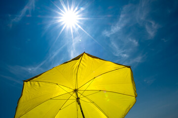 Yellow Umbrella with Bright Sun and Blue Sky