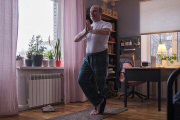 Fototapeta na wymiar Senior man working out, yoga in basic standing asana tadasana, mountain posture