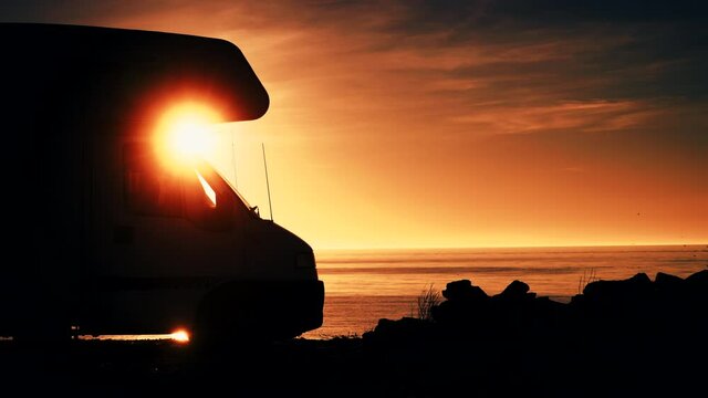 Camper rv camping on coast sea shore at sunrise. Adventure, travel with mobile home.