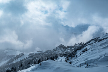 Fototapeta na wymiar Stormy clouds in italian dolomites in a snowy winter