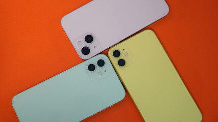 Three newest smartphones on the orange table