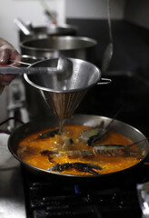 chef elaborando paella de marisco con bogavante