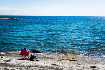 Persona acostada en una silla frente a la playa viendo el paisaje, ambiente turistico