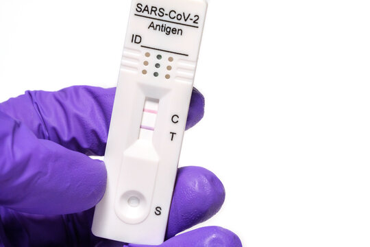 hand holding COVID-19 rapid antigen test positive result, immunochromatography of antibodies to detect infections