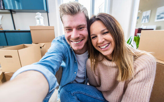 Husband and wife take a selfie moving in new home - Young couple just moved into new apartment - People and relocation concept..