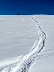 Snowmobile high mark track in the snow that leads to the sky above