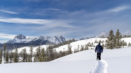 Man snowshoes into the Idaho wilderness in winter snow