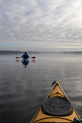 Paddeln mit dem Kajak auf einem einsamen See bei Nebel
