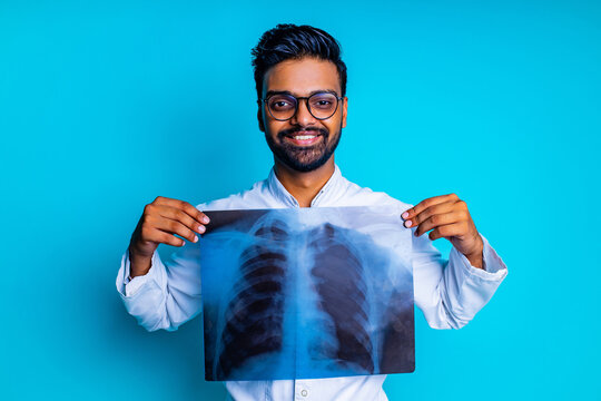 Indian Doctor Showing Chest Bone Film X-ray Image In Blue Studio Baclground