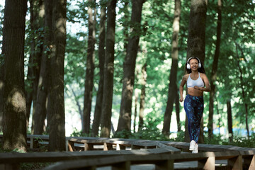 Young girl enjoying outdoors workout - young attractive and fit afro American woman running at countryside road in sport practice concept and healthy lifestyle
