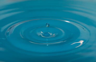 water droplet falls into water with ripples