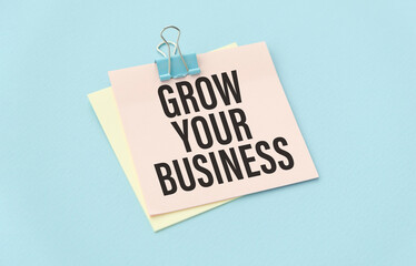 grow your business, text on white paper on blue table.