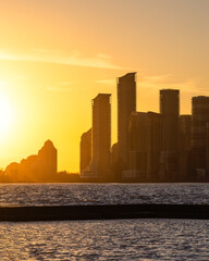 Waterfront city skyline silhouetted in front of a golden winter sunset