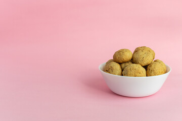 Oatmeal cookies on a white plate on a pink background with space for text on the left. Healthy food concept. High-quality photo