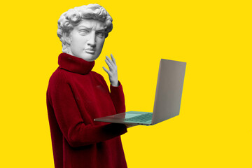 Abstract modern collage. The man with the plaster head of David in a red sweater looks at a laptop screen on a yellow background - obrazy, fototapety, plakaty