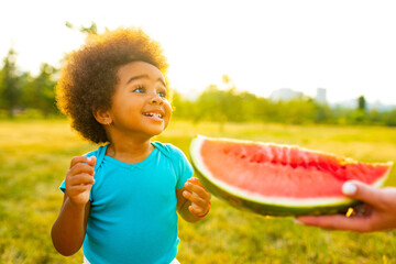 african american girl with watermelon in park on summer sunset day