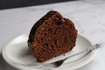 Close-up view of a piece of homemade chocolate cake. Served on a cake plate.