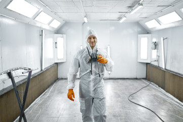 Portrait automobile painter standing in paint chamber