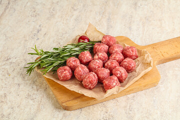 Raw uncooked beef meatballs served rosemary