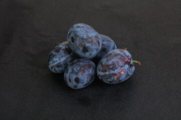 Ripe plum heap over background