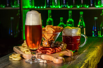 Mugs of green beer, ale on the bar counter. Holiday of Ireland on St. Patrick's Day in irish pub, bar. Festive Leprikon's green hat. National tradition of carnival celebrating March 17