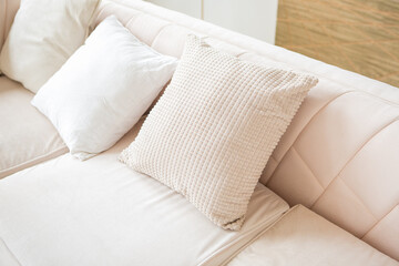 Fototapeta na wymiar Beige pillows on a light sofa in an apartment