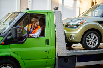 Tow truck driver delivering car to autoservice