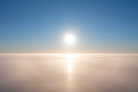 Aerial view white clouds in blue sky. View from drone. Aerial top view cloudscape. Texture of clouds. View from above. Sunrise or sunset over clouds