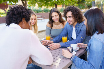 Group of diverse friends chilling in street cafe