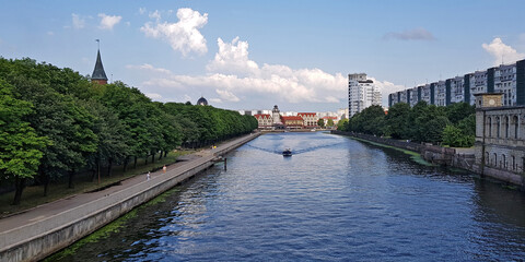 Fototapeta na wymiar embankment of the river channel with a boat on the background of ancient and modern buildings